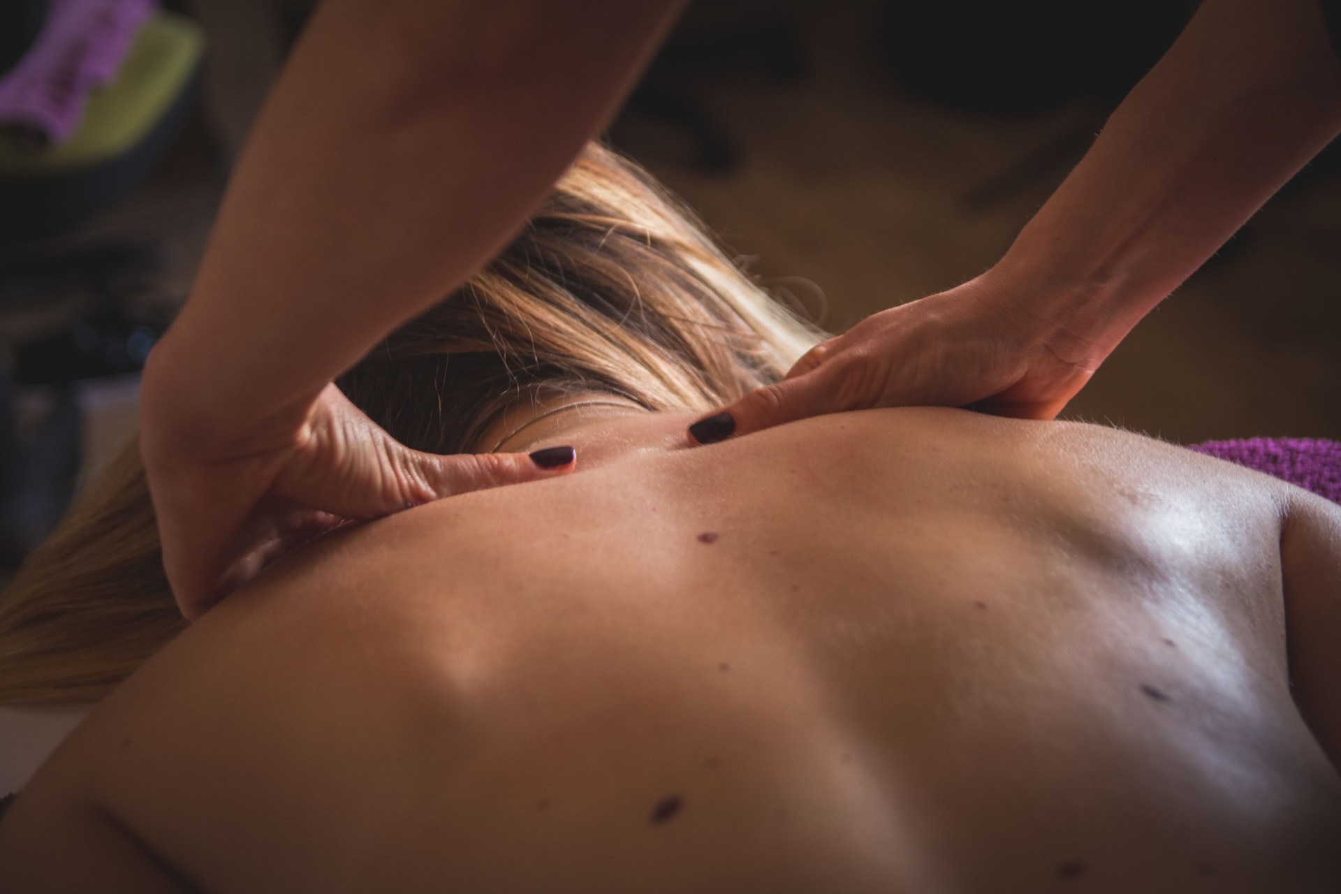 Young woman having a neck massage in beauty spa salon